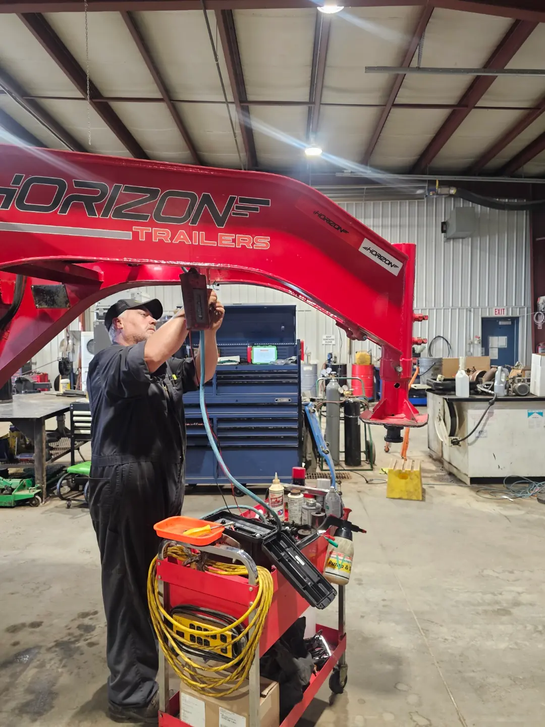 Tool raised to the red trailer underside, cart in foreground